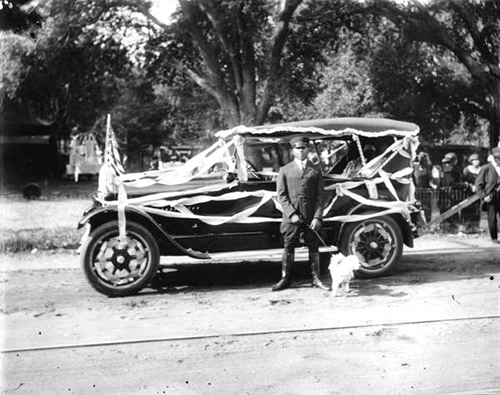 Historic photo of Wilbur Julius & Toy Poodle Beside Parade Car