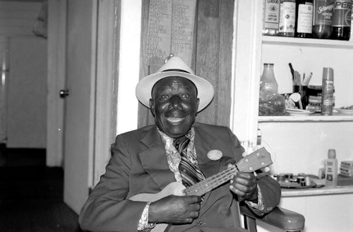 Photo of William "Washboard Bill" Cooke poses with his ukulele