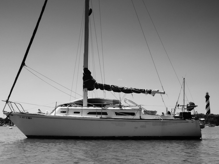 Picture of sailboat in front of lighthouse