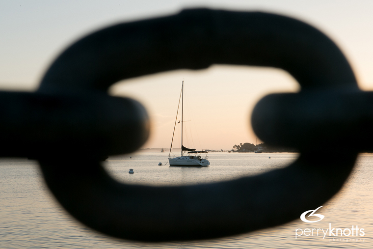 A sailboat is framed by a chain along the bayfront in St. Augustine, FL. Photo by Perry Knotts.
