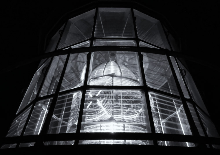 Night view of lighthouse lens up close at night