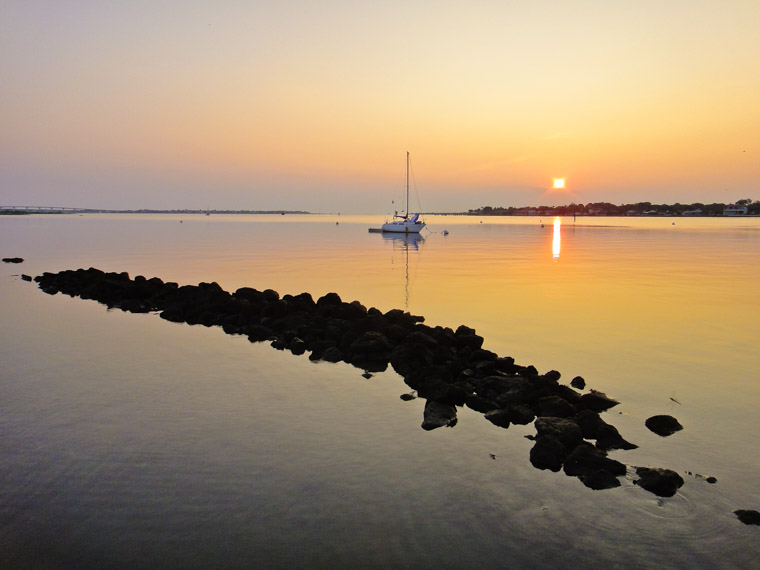 Intracoastal sunrise sailboat wave break