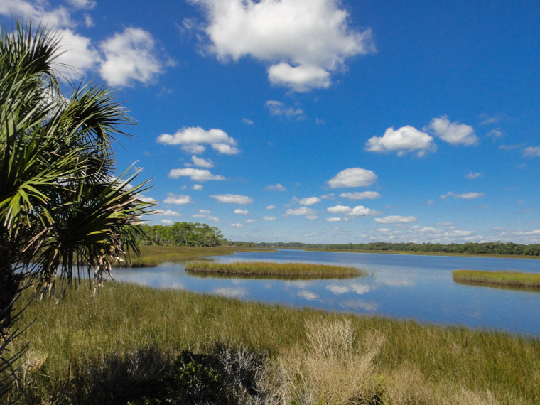 Clouds and sun over marsh at Princess Place