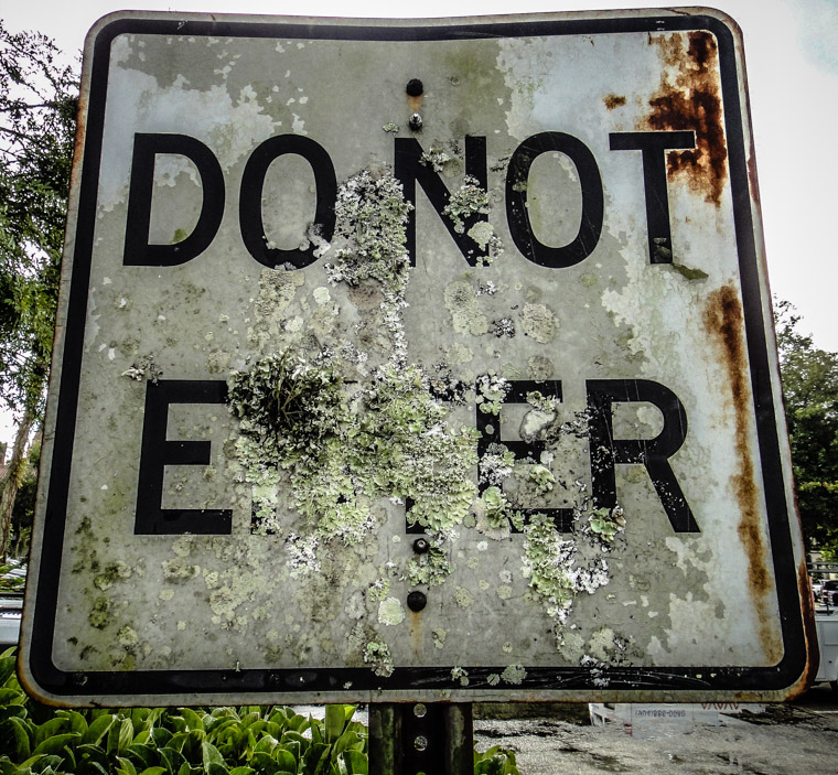 Rusty sign covered in lichen do not enter