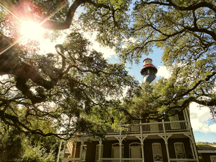 Lighthouse and sunshine with live oaks