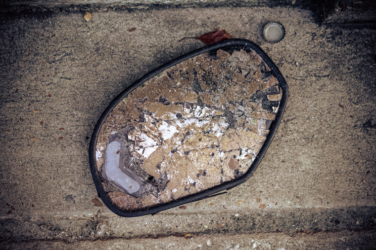 Broken rear view mirror on concrete