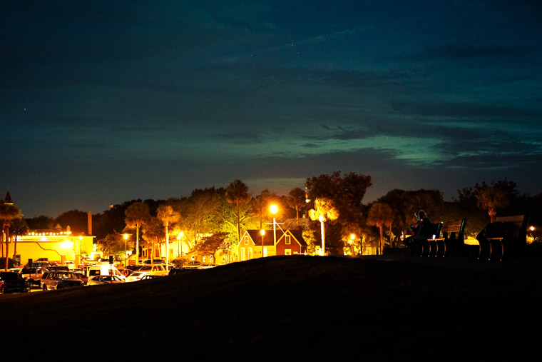 People sitting on bench at night at fort