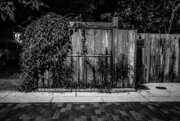 Wooden fence and street at night