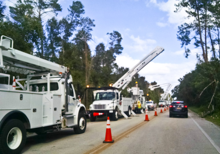 Electric company bucket trucks working on power lines